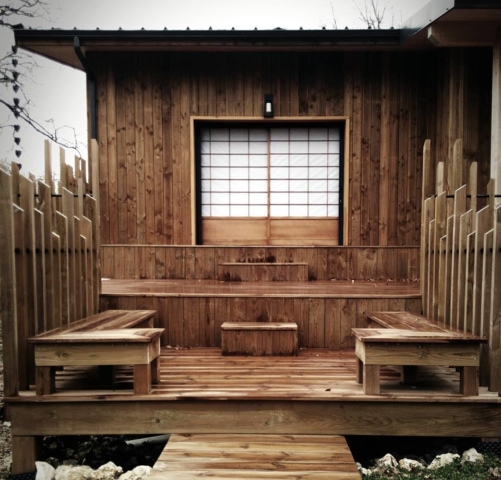 Vue extérieure du Ryokan en bois avec terrasses invitant à la méditation