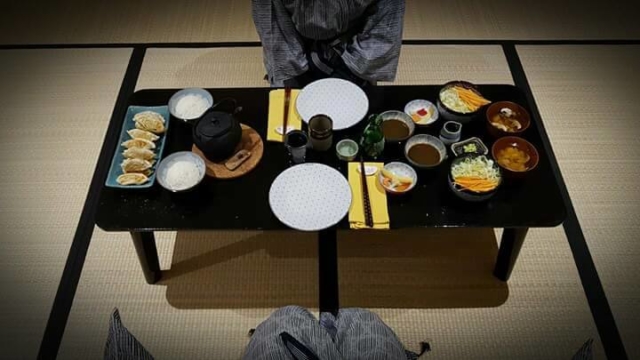 Repas dans le Ryokan sur table basse avec salade, soupe miso, gyosas, riz et thé